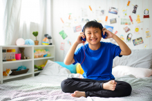 Child listening to music on bed
