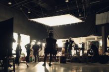 Image of film crew silhouettes working on set.